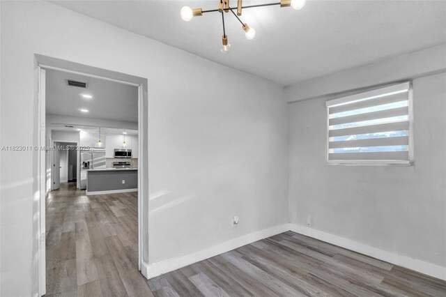 4622 SW 23rd St, West Park, FL 33023 - spare room with wood finished floors and a chandelier
