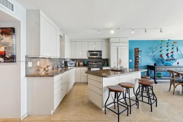 6423 Collins Ave Unit 1605, Miami Beach, FL 33141 - kitchen with stainless steel microwave, black range with electric stovetop, a kitchen bar, dark countertops, and a kitchen island