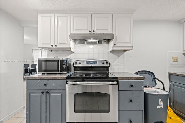 17845 SW 112th Ct, Miami, FL 33157 - kitchen with appliances with stainless steel finishes, under cabinet range hood, gray cabinets, tasteful backsplash, and white cabinetry