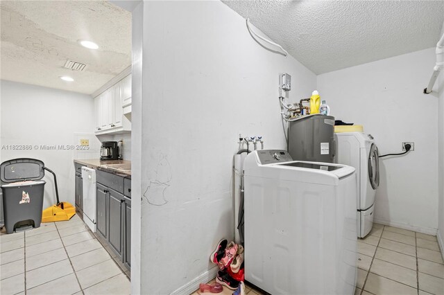 17845 SW 112th Ct, Miami, FL 33157 - laundry room with a textured ceiling, washing machine and dryer, electric water heater, light tile patterned floors, and cabinet space