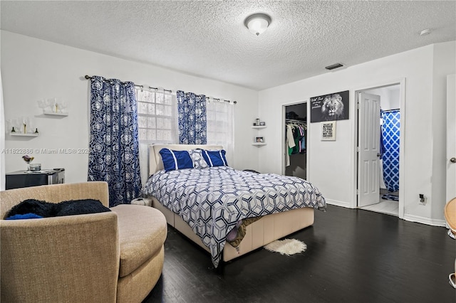 17845 SW 112th Ct, Miami, FL 33157 - bedroom with dark wood-type flooring, a textured ceiling, a walk in closet, a closet, and connected bathroom