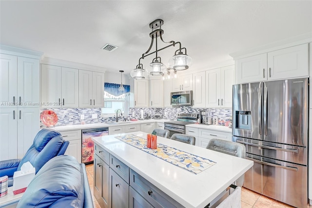 30 Bunker Ln Fl, Grove City-Rotonda, FL 33947 - kitchen featuring appliances with stainless steel finishes, light countertops, white cabinets, decorative backsplash, and open floor plan
