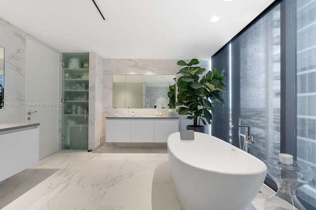 1000 Biscayne Blvd Unit 3402, Miami, FL 33132 - bathroom featuring vanity, a freestanding tub, marble tiled floors, and stone wall