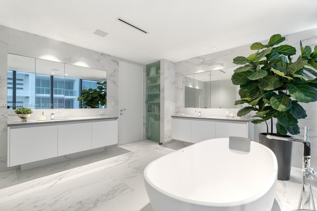 1000 Biscayne Blvd Unit 3402, Miami, FL 33132 - full bathroom featuring two vanities, a soaking tub, marble tiled flooring, and stone wall