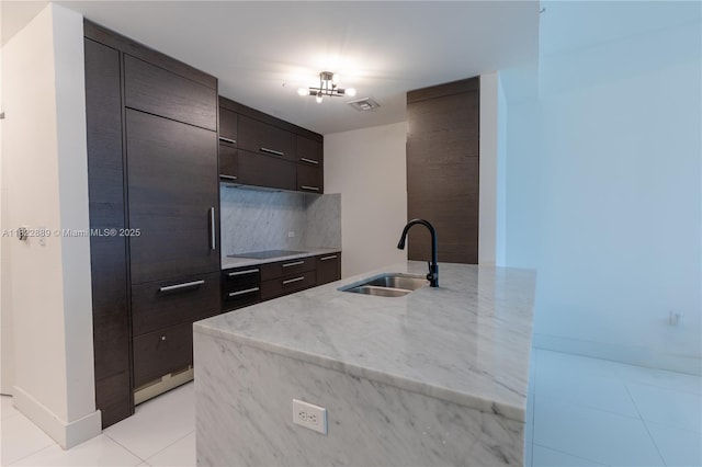 900 Biscayne Blvd Unit 2210, Miami, FL 33132 - kitchen with modern cabinets, black electric stovetop, light tile patterned floors, backsplash, and dark brown cabinets