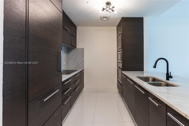 900 Biscayne Blvd Unit 2210, Miami, FL 33132 - kitchen featuring black electric cooktop, light stone counters, light tile patterned floors, decorative backsplash, and modern cabinets