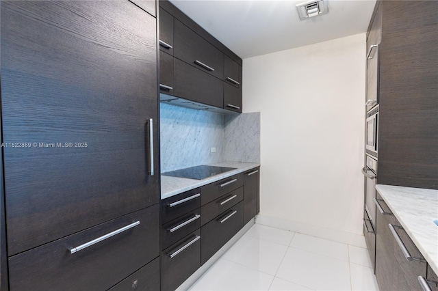 900 Biscayne Blvd Unit 2210, Miami, FL 33132 - kitchen featuring stainless steel appliances, modern cabinets, tasteful backsplash, light tile patterned floors, and dark cabinets