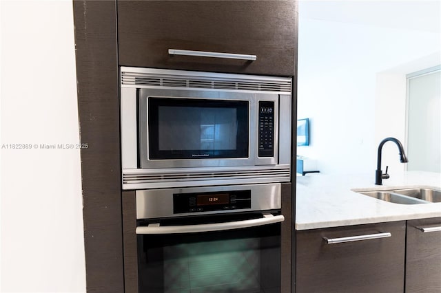 900 Biscayne Blvd Unit 2210, Miami, FL 33132 - kitchen view of appliances with stainless steel finishes, dark brown cabinets, light stone counters, and modern cabinets