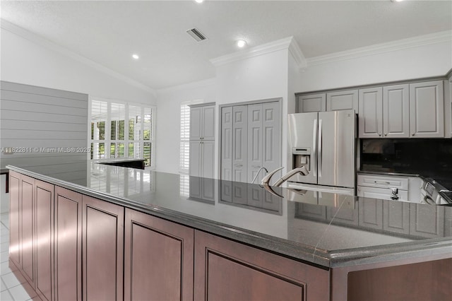 2278 SW Olympic Club Ter, Palm City, FL 34990 - kitchen with stainless steel fridge with ice dispenser, dark stone countertops, vaulted ceiling, crown molding, and recessed lighting