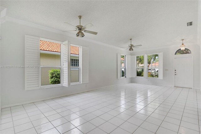 2278 SW Olympic Club Ter, Palm City, FL 34990 - spare room with ceiling fan, ornamental molding, light tile patterned flooring, and a textured ceiling