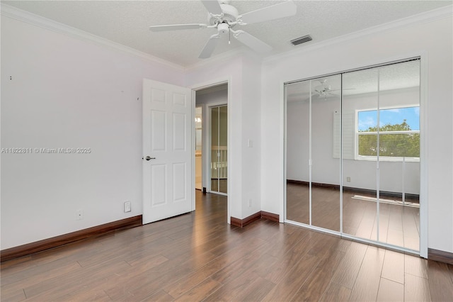 2278 SW Olympic Club Ter, Palm City, FL 34990 - unfurnished bedroom featuring a textured ceiling, wood finished floors, a closet, crown molding, and ceiling fan