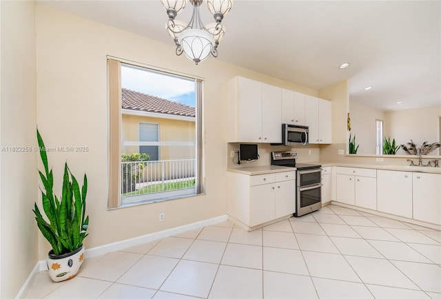 1001 SW 189th Ave, Pembroke Pines, FL 33029 - kitchen featuring appliances with stainless steel finishes, light countertops, a chandelier, white cabinetry, and pendant lighting