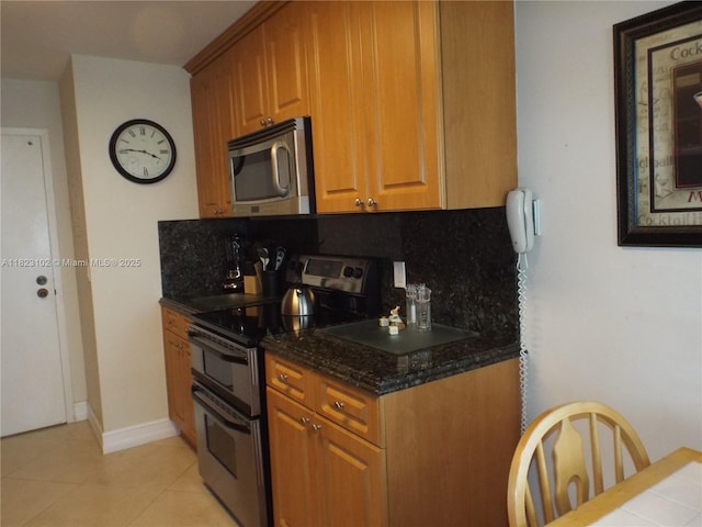 1890 S Ocean Dr Unit 504, Hallandale Beach, FL 33009 - kitchen featuring appliances with stainless steel finishes, decorative backsplash, dark stone counters, and brown cabinets