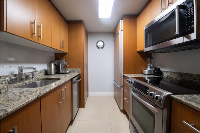 10275 Collins Ave Unit 330, Bal Harbour, FL 33154 - kitchen with stainless steel appliances, brown cabinets, and light stone counters