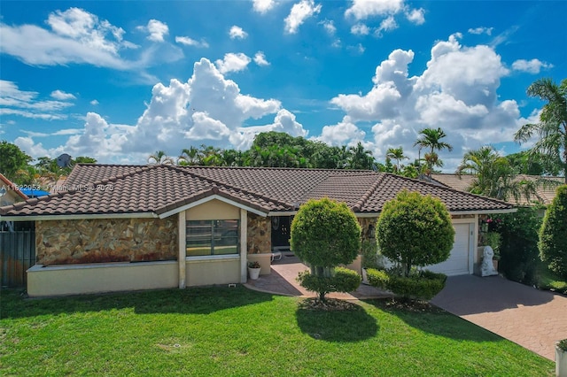 20045 NW 65th Ct, Hialeah, FL 33015 - view of front of house with stone siding, decorative driveway, an attached garage, a tiled roof, and a front lawn