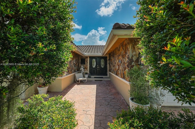 20045 NW 65th Ct, Hialeah, FL 33015 - doorway to property featuring stone siding, a tile roof, and a patio