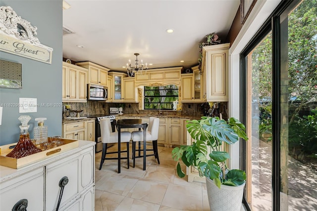 20045 NW 65th Ct, Hialeah, FL 33015 - kitchen with stainless steel microwave, stove, cream cabinets, and recessed lighting