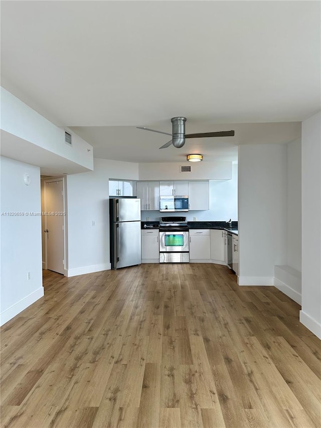 1330 W Ave Unit 3007, Miami Beach, FL 33139 - kitchen with appliances with stainless steel finishes, dark countertops, ceiling fan, and light wood-style flooring
