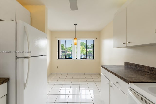 9455 N Belfort Cir Unit 211, Tamarac, FL 33321 - kitchen with freestanding refrigerator, dark countertops, white cabinets, and light tile patterned floors