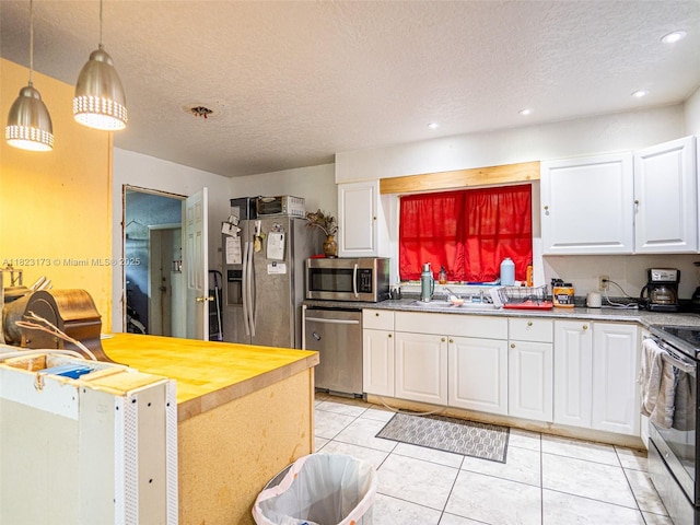907 S Amelia Ave, Deltona, FL 32724 - kitchen with appliances with stainless steel finishes, white cabinets, a textured ceiling, light tile patterned floors, and recessed lighting