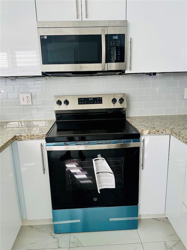 18961 NW 22nd St, Pembroke Pines, FL 33029 - kitchen with appliances with stainless steel finishes, light marble finish floors, white cabinetry, tasteful backsplash, and light stone counters