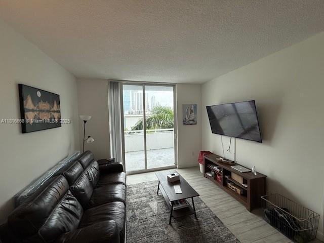 275 NE 18th St Unit 402, Miami, FL 33132 - living room featuring light wood-style flooring, floor to ceiling windows, and a textured ceiling