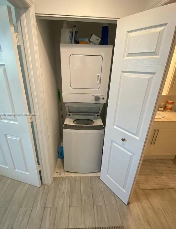 275 NE 18th St Unit 402, Miami, FL 33132 - laundry area featuring stacked washer / dryer and light wood-style flooring