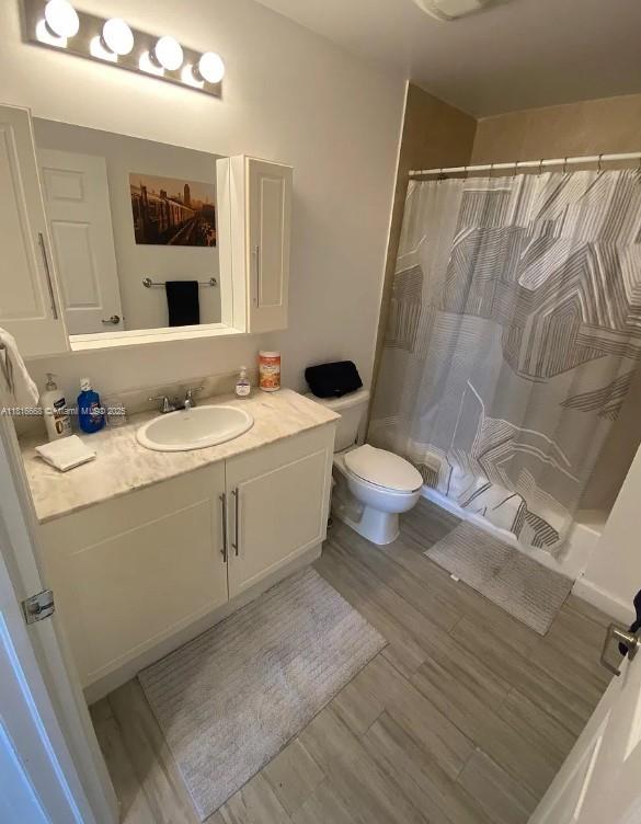 275 NE 18th St Unit 402, Miami, FL 33132 - bathroom with vanity, wood finished floors, and a shower with shower curtain