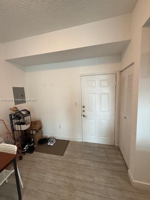 275 NE 18th St Unit 402, Miami, FL 33132 - foyer entrance featuring light wood-style flooring, electric panel, and a textured ceiling