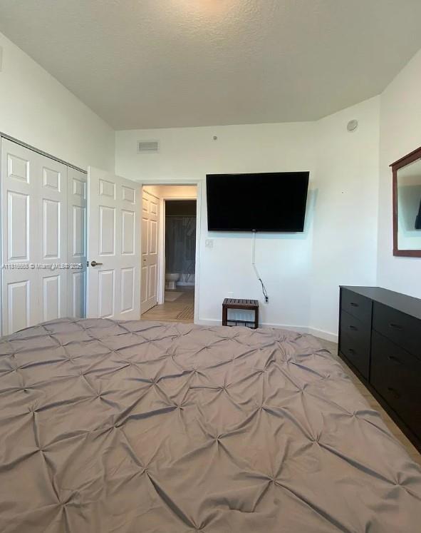 275 NE 18th St Unit 402, Miami, FL 33132 - bedroom featuring a closet and baseboards