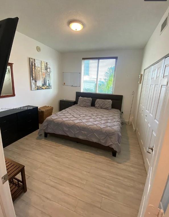 275 NE 18th St Unit 402, Miami, FL 33132 - bedroom featuring light wood-type flooring and a closet