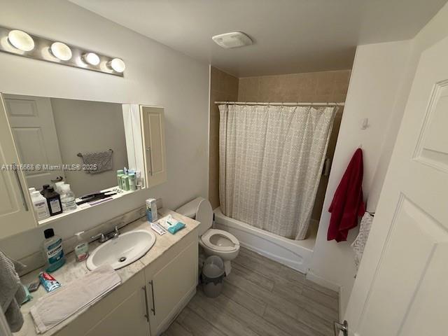 275 NE 18th St Unit 402, Miami, FL 33132 - bathroom featuring vanity, shower / bath combo with shower curtain, and wood finished floors