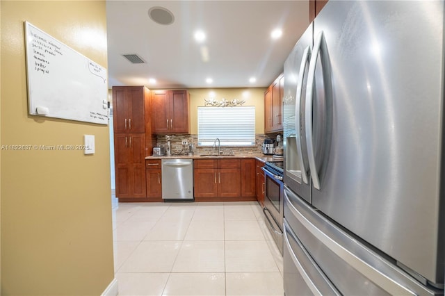 11351 NW 37th St, Coral Springs, FL 33065 - kitchen with stainless steel appliances, backsplash, light tile patterned floors, brown cabinets, and recessed lighting