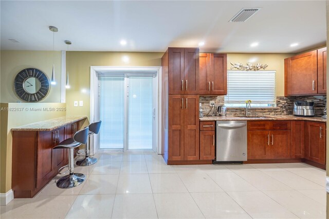 11351 NW 37th St, Coral Springs, FL 33065 - kitchen with dishwasher, light stone counters, backsplash, decorative light fixtures, and a kitchen breakfast bar