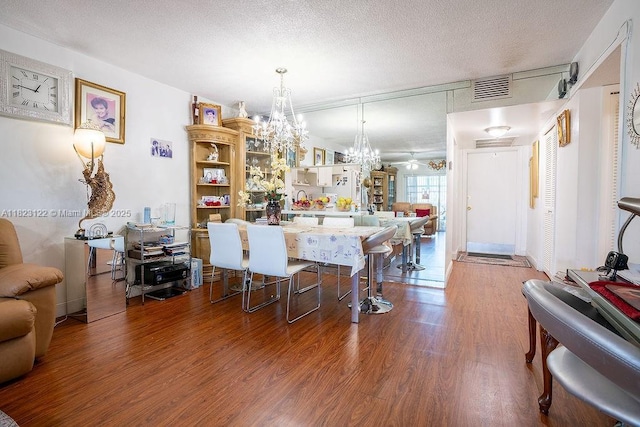 215 SE 3rd Ave Unit 405C, Hallandale Beach, FL 33009 - dining area featuring a chandelier, wood finished floors, and a textured ceiling