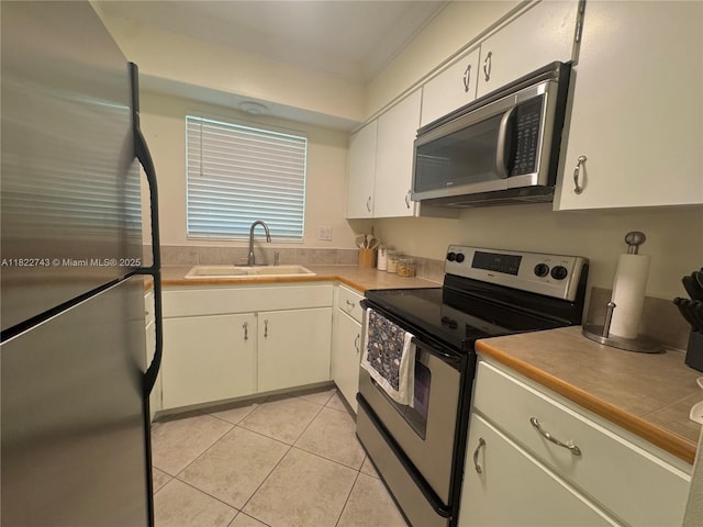 3801 NE 22nd Ter Unit 7, Lighthouse Point, FL 33064 - kitchen with stainless steel appliances, light tile patterned flooring, and white cabinetry