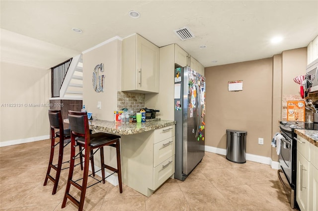 6797 SW 40th St Unit 71, Davie, FL 33314 - kitchen featuring stainless steel appliances, light stone countertops, white cabinets, tasteful backsplash, and a breakfast bar area
