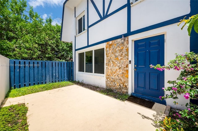 6797 SW 40th St Unit 71, Davie, FL 33314 - view of exterior entry with stone siding, stucco siding, and a patio area