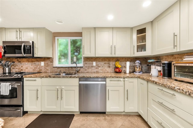 6797 SW 40th St Unit 71, Davie, FL 33314 - kitchen with stainless steel appliances, light tile patterned floors, decorative backsplash, light stone counters, and recessed lighting