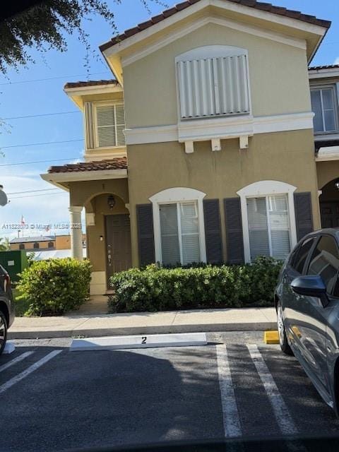 8960 W Flagler St Unit 1, Miami, FL 33174 - view of front facade featuring stucco siding, uncovered parking, and a tiled roof