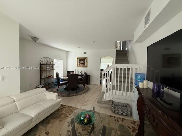 8960 W Flagler St Unit 1, Miami, FL 33174 - living area with stairway, healthy amount of natural light, arched walkways, and tile patterned floors