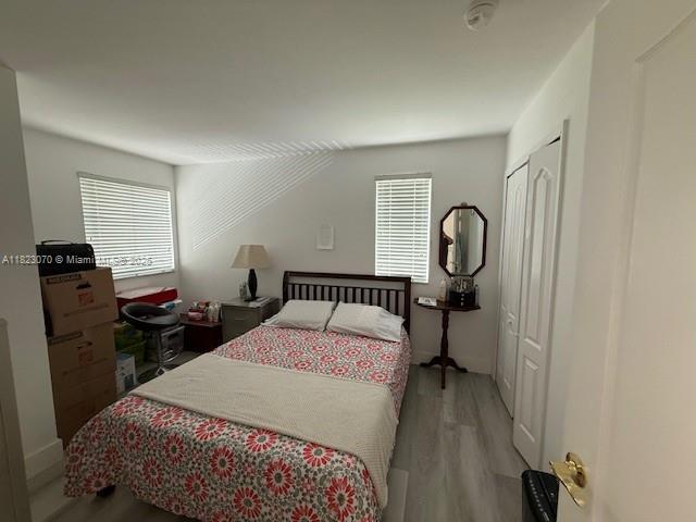 8960 W Flagler St Unit 1, Miami, FL 33174 - bedroom with wood finished floors, multiple windows, and a closet