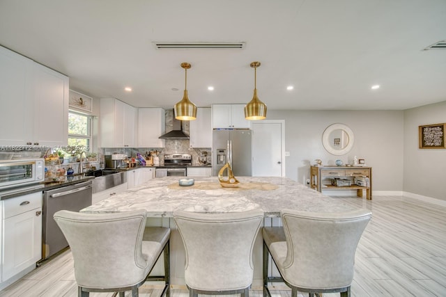 9104 SW 180th St, Palmetto Bay, FL 33157 - kitchen with stainless steel appliances, wall chimney range hood, a center island, decorative backsplash, and white cabinets