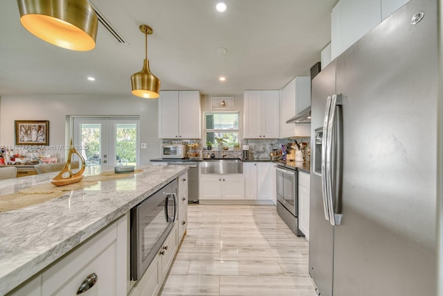 9104 SW 180th St, Palmetto Bay, FL 33157 - kitchen with stainless steel appliances, plenty of natural light, white cabinets, light stone counters, and recessed lighting