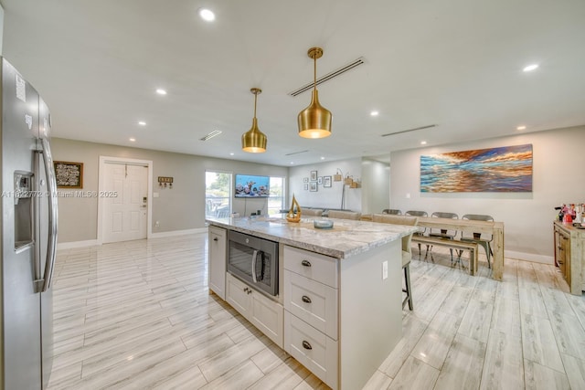 9104 SW 180th St, Palmetto Bay, FL 33157 - kitchen with stainless steel appliances, white cabinets, a center island, recessed lighting, and light stone countertops