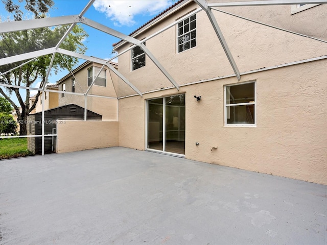 457 NW 87th Ln, Coral Springs, FL 33071 - back of property featuring stucco siding, a patio area, and glass enclosure