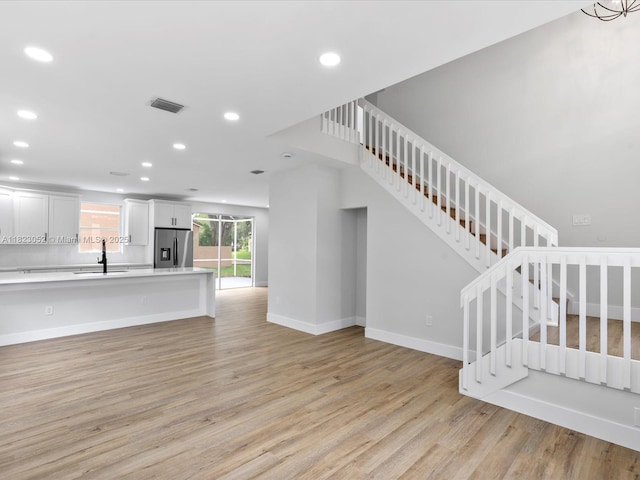 457 NW 87th Ln, Coral Springs, FL 33071 - unfurnished living room with recessed lighting, light wood-style flooring, and stairway