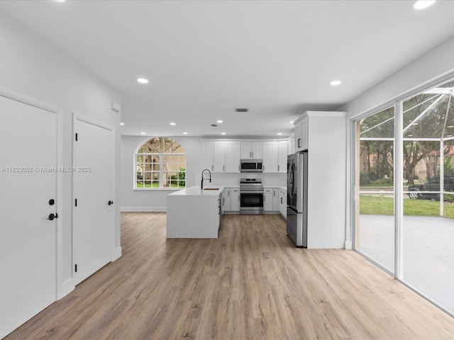 457 NW 87th Ln, Coral Springs, FL 33071 - kitchen featuring stainless steel appliances, light countertops, plenty of natural light, recessed lighting, and light wood finished floors