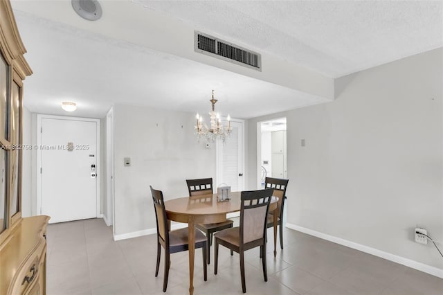 1020 Meridian Ave Unit 616, Miami Beach, FL 33139 - dining room with tile patterned flooring, a chandelier, and a textured ceiling