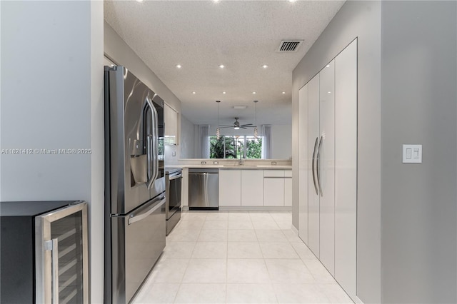 1654 SW 109th Ter, Davie, FL 33324 - kitchen featuring stainless steel appliances, wine cooler, light countertops, modern cabinets, and white cabinets